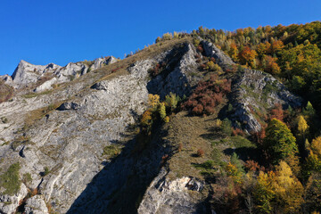 Aerial view of rocky limestone mountains and autumn forest