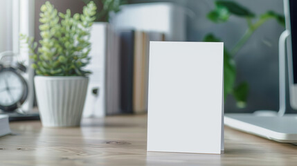 Fototapeta premium Blank white card mockup, upright display on a simple desk, minimalist design, clean lines, showcasing potential for personalized messages or branding.