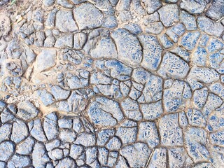Unique cracked earth surface with blue highlights in a dry landscape during daylight