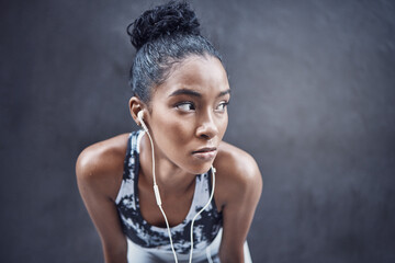 African woman, workout and break with earphones and thinking with run and marathon training with space. Sport, music and audio with breathing and streaming fitness track for health and wellness