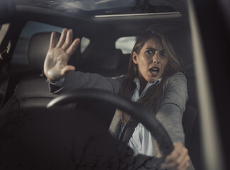 Shocked woman sitting in car