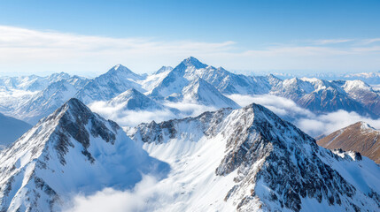 Obraz premium Majestic snow covered mountain peaks rise above low clouds, creating breathtaking view