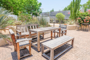 Obraz premium Empty Wooden Table and chairs inside desert House or hotel with bougainvillea flower and cactus,summer spanish bougainvillea flowers with blue sky,selective focus.