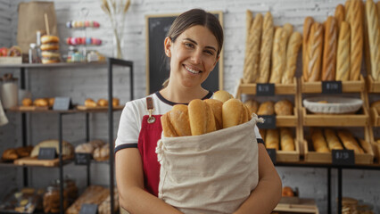 Woman holding bread at bakery smiling, adult, attractive, brunette, hispanic, indoors, shop, delicious, fresh.