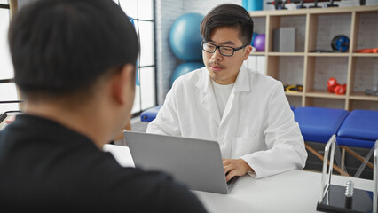Two men, a doctor and a patient, engage in a discussion inside a modern clinic's consultation room.