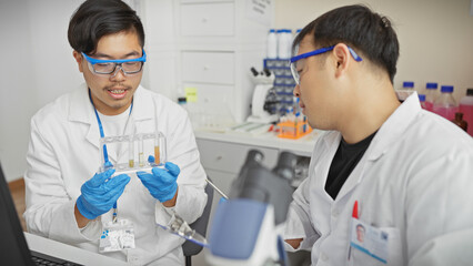 Two men in a laboratory analyzing samples together, embodying teamwork and scientific inquiry indoors.