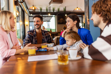Friends hanging out at the cafe. They drink and talk.