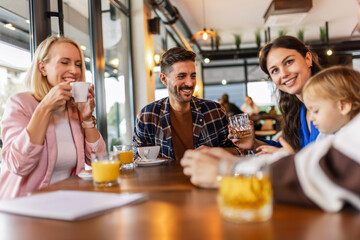 Friends hanging out at the cafe. They drink and talk.
