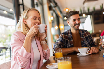Friends hanging out at the cafe. They drink and talk.