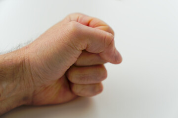 Close-up of fist of male hand of adult against white background. Photo taken October 19th, 2024, Zurich, Switzerland.