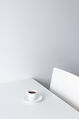 Cup of espresso coffee on the white table. Blank copy space.