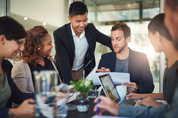 Team, meeting and man in office with advice, leadership and feedback report on sales growth. Management, development and business people in conference room with ideas, strategy and planning documents