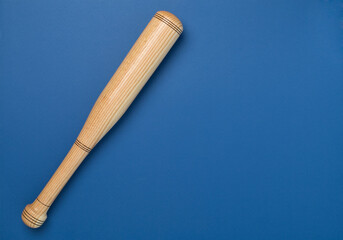 Wooden baseball bat on color background, top view