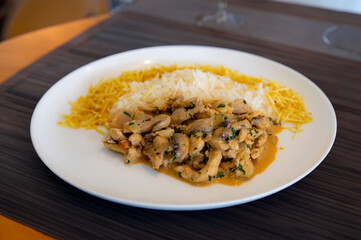 Traditional chicken stroganoff with mushrooms, straw potatoes and white rice