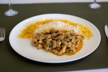 Traditional chicken stroganoff with mushrooms, straw potatoes and white rice