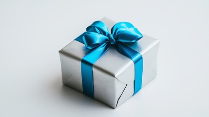 Fototapeta premium Small square gift box wrapped in silver paper, with a blue ribbon on a white background