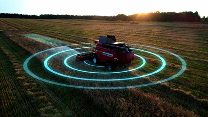 Aerial view. Automated electric harvester cutting crops on farms. Graphics showing battery levels and artificial intelligence-assisted navigation.