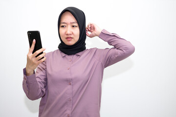 Asian, Indonesian woman wearing purple clothes with angry and upset expression. Her hands are like wanting to scratch, her hands are on her head. isolated in white background