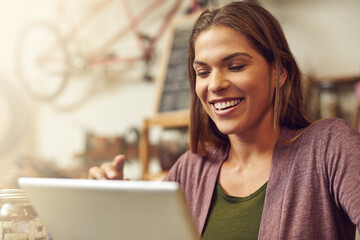 Small business, woman and happy with tablet at bicycle shop on break, social media and networking. Female person, store assistant and smile as employee for with reviews for service and repairs