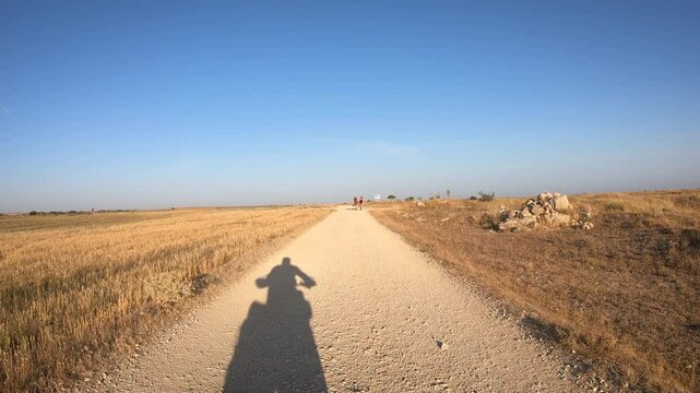 French Way of Saint James - pilgrims walking the Camino at Alto de Mostelares on the way to Itero de la Vega, province of Palencia, Castile and Leon, Spain