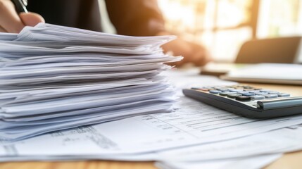 Office Desk with Stacked Papers and Calculator in Focus