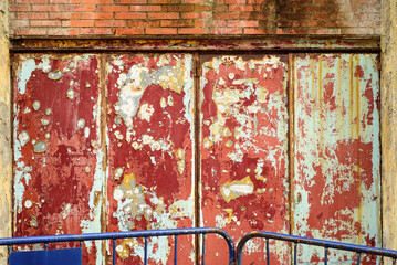 Pared de metal oxidada y corroida con pintura rojo