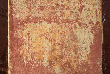 Pintura roja caída en pared exterior