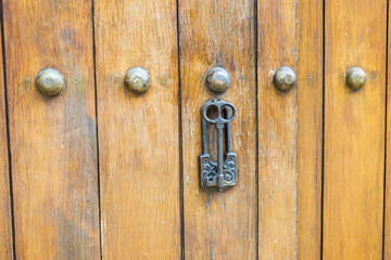 Close up of old Key in wooden door at home, Brown Wood Front Door with Ornate Brass Skeleton...
