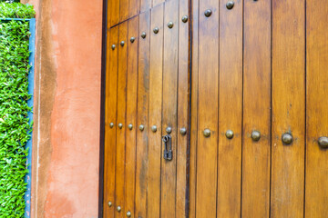 Close up of old Key in wooden door at home, Brown Wood Front Door with Ornate Brass Skeleton...