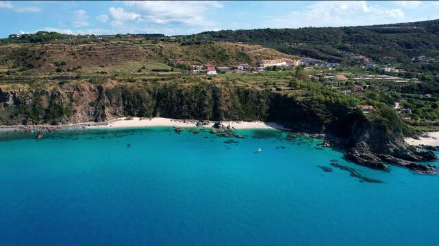 4K Aerial drone video of one of the most beautiful beaches in the world with turquoise clear blue water and white sand with big rocks on a sunny summer day. Marinella di Zambrone Paradiso Tropea Italy