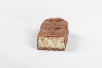 Candy bar with coconut pulp, in milk chocolate. White background. Close up