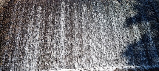 water flowing over small concrete dam connected to hydro electrical power production