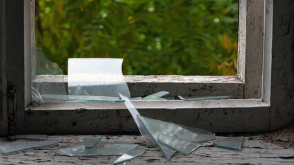 Smashed glass Window with old wooden frame. old window. finely broken glass. old house, retro. cracked window frame. cracked old paint, pieces of glass. close-up, space for text. large pieces of glass