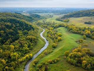 Serene Meandering River in Autumn Valley - Aerial View of Tranquil Nature with Cityscape on Horizon