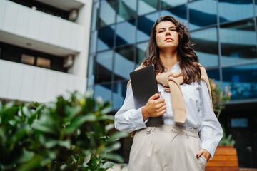 Fototapeta premium Young businesswoman going to work in front of modern business building