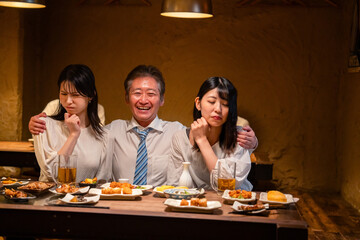 宴会の席で女性と肩を組むビジネスマン