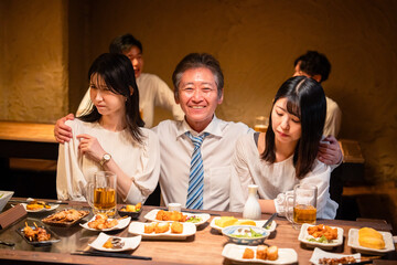 宴会の席で女性と肩を組むビジネスマン