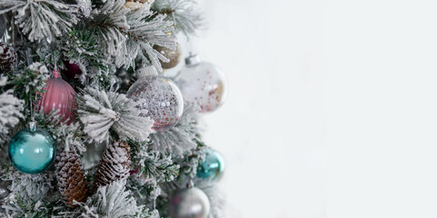 new year tree decorated with pastel colored balls and cones, frost on the branches, and empty space for text on the right side, soft lighting, winter holiday mood, festive and calm atmosphere