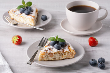 Delicious homemade cake served with fresh fruit and coffee on a rustic wooden table in a cozy morning setting