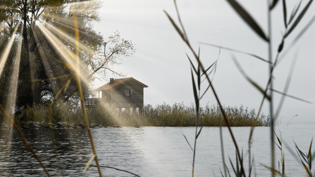 Tiny house by the lake in shot in an early morning with sunrays striking towards the weter.