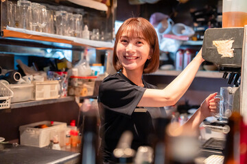 飲食店でビールサーバーを使う女性の店員