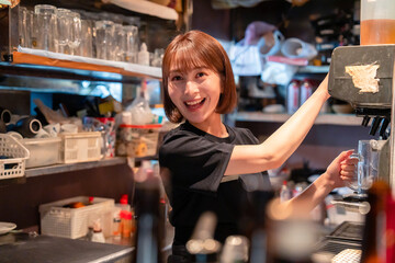 飲食店でビールサーバーを使う女性の店員