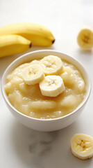 Freshly pureed banana in white baby bowl for healthy infant meals