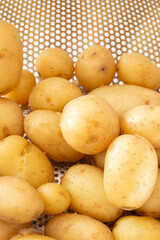 Boiled whole new potatoes in a stainless steel colander strainer utensil