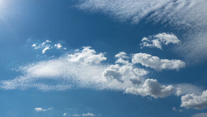 spring or summer blue sky with light fluffy clouds. nice serene weather. peaceful cloudscape in...