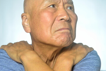 肩こりで悩む老人のクローズアップ