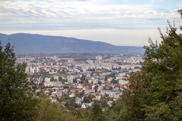 Fototapeta premium Skopje, a thriving urban panorama The city of Skopje, seen from above Aerial view of the Macedonian capital Skopje, a mosaic of colors and shapes where the mountains meet the metropolis.