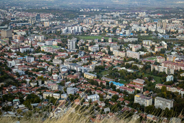 Naklejka premium Skopje, a thriving urban panorama The city of Skopje, seen from above Aerial view of the Macedonian capital Skopje, a mosaic of colors and shapes where the mountains meet the metropolis.