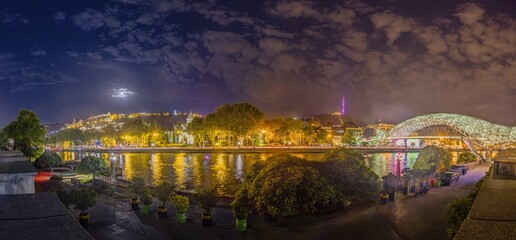Peace Bridge in Tbilisi, Georgia, illuminated at night over the Kura River, captured in artificial light © Aquarius