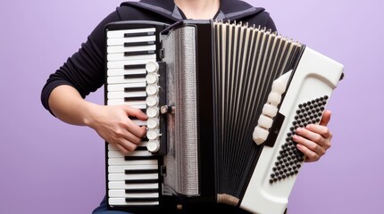 A musician plays a classic accordion with a black and white color scheme against a purple backdrop in a creative space